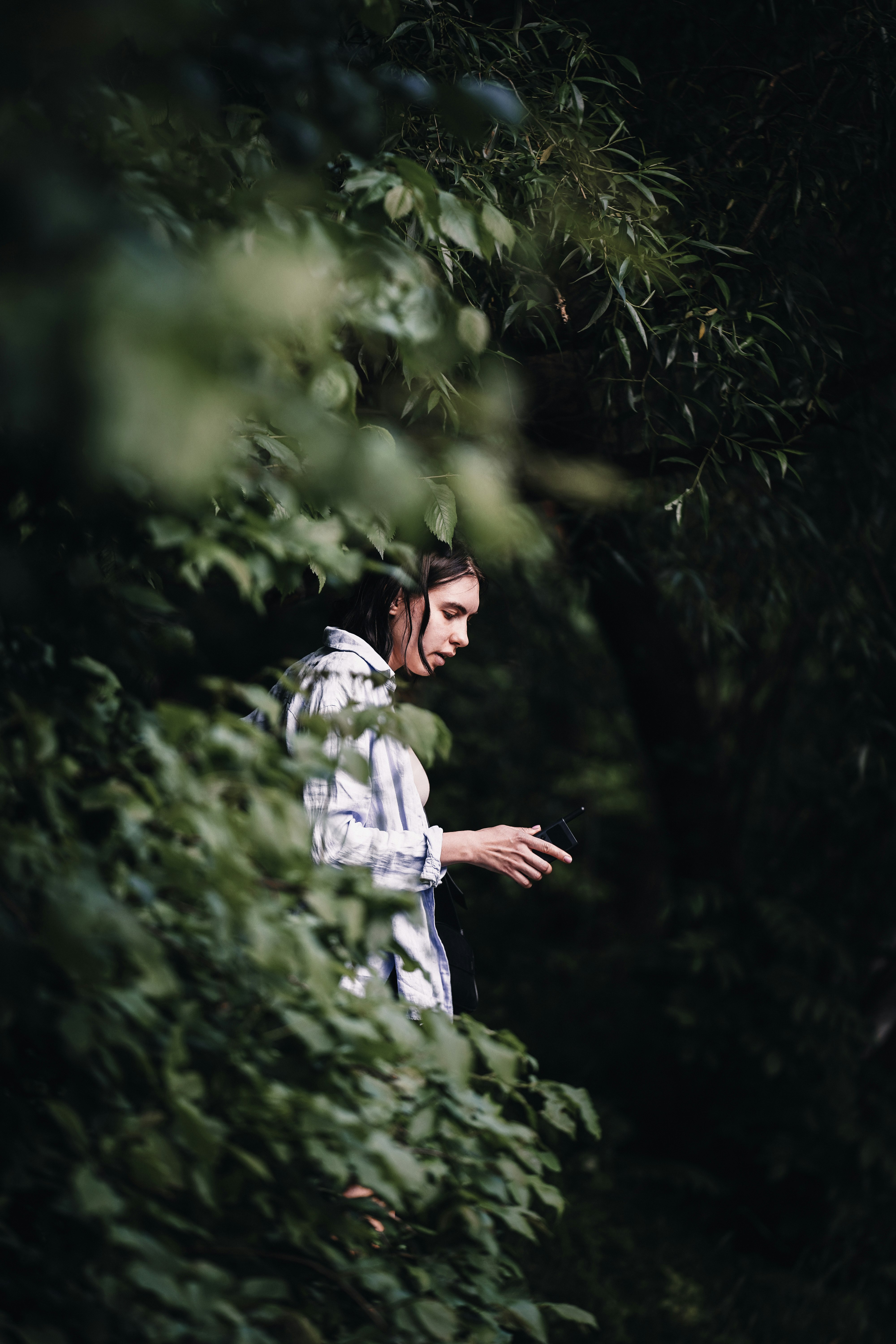 man in white and black long sleeve shirt standing near green trees during daytime